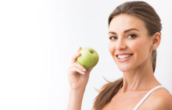 attractive woman holding an apple and smiling, Lawrenceville, GA